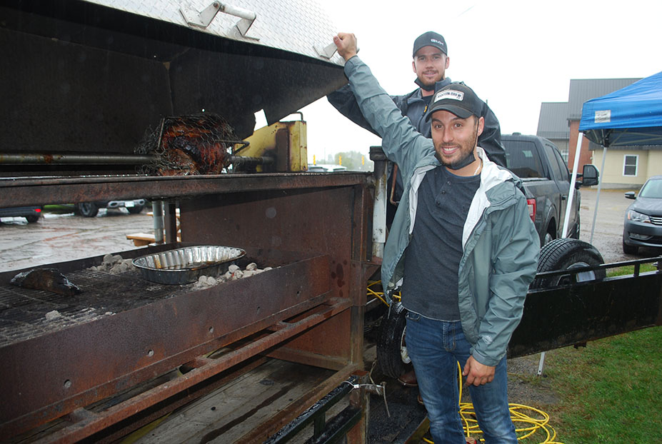 Trevor Heney, top, and Jesse Zito were roasting a couple of turkeys for the take-out dinner plates offered at the Luskville Market.
